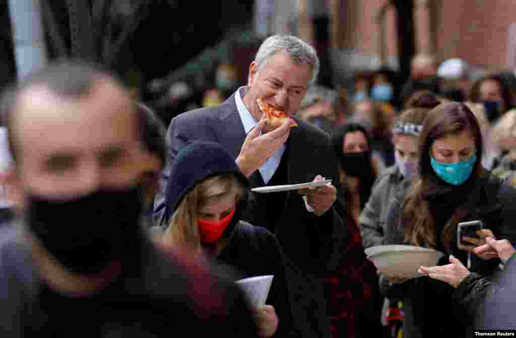 미국 뉴욕주 브루클린에서 사전투표에 참여한 빌 블라지오 뉴욕시장이 줄을 선 채 피자를 먹고 있다. 
