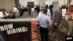 In this July 13, 2011 photo, National Tire & Battery area director Don Hudome, right, meets with an attendee at a National Career Fairs Job Fair, in Dallas. More people applied for unemployment benefits last week, evidence that layoffs are rising and the 