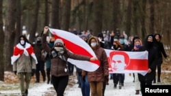 Opposition supporters carry historical white-red-white flags of Belarus as they attend a rally to reject the presidential election results in Minsk, Belarus, Dec. 13, 2020. 