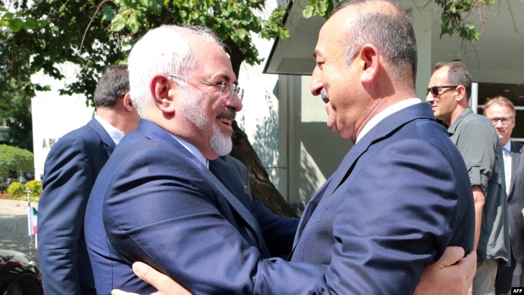 Turkish Foreign Minister Mevlut Cavusoglu, right, welcomes Iranian counterpart Mohammad Javad Zarif at the foreign ministry in Ankara, Aug. 12, 2016.