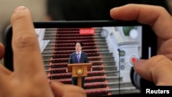 A person films Taiwan's President Lai Ching-te as he holds a news conference in Taipei, Taiwan, Feb. 14, 2025.