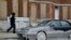 A man walks past a car partially covered in ice in Baltimore, Maryland, where temperatures continue to remain well below freezing. An arctic blast eased its grip on much of the U.S., with winds calming and the weather warming slightly a day after temperature records shattered up and down the Eastern Seaboard.