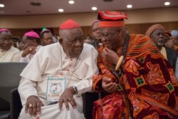 FILE - Cardinal Christian Wiyghan Tumi, left, talks with Cameroonian veteran opposition leader John Fru Ndi at the Congress Palace during the opening session of the National Dialogue, in Yaounde, Cameroon, Sept. 30, 2019.