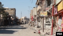 The main street in the Dawasa neighborhood of western Mosul was a hub for restaurants and nightlife more than a decade ago. Now the shops are burnt out or destroyed and the area is abandoned, March 10, 2017. (H. Murdock/VOA)