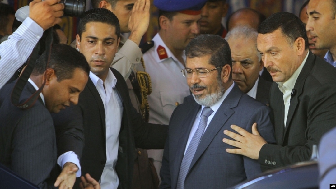 Egypt's President-elect Mohammed Morsi is guarded by presidential security as he leaves Friday prayers at Al-Azhar mosque, in Cairo, Egypt, Friday, June 29, 2012.