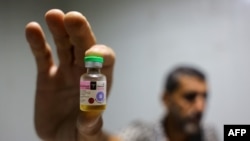 A worker shows a vial containing a polio vaccine provided with support from UNICEF to the Gaza Strip through the Karm Abu Salem crossing, also known as Kerem Shalom, at a depot belonging to Gaza's Health Ministry, Aug. 25, 2024.