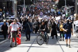 Ratusan warga memrotes pembatasan pemerintah terkait COVID-19 di kota Melbourne, Australia (21/8) lalu.
