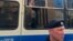 Arhiv - Policajac stoji ispred autobusa sa novinarima uhapšenim tokom mitinga u Moskvi, 7. jula 2019.