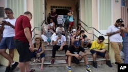 People congregate at a wifi hotspot in the aftermath of Hurricane Maria with many cellphone towers down in San Juan, Puerto Rico, Sept. 24, 2017.