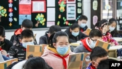 Elementary school students wearing face masks attend a class as they return to school after the start of the term was delayed due to the COVID-19 coronavirus outbreak, in Huaian in China's eastern Jiangsu province, Apr. 7, 2020.