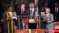 Kenya's President Uhuru Kenyatta takes the oath of office as his wife Margaret holds a bible during the official swearing-in ceremony at Kasarani Stadium in Nairobi, April 9, 2013. 