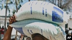 A woman looks happy after receiving bags of food 