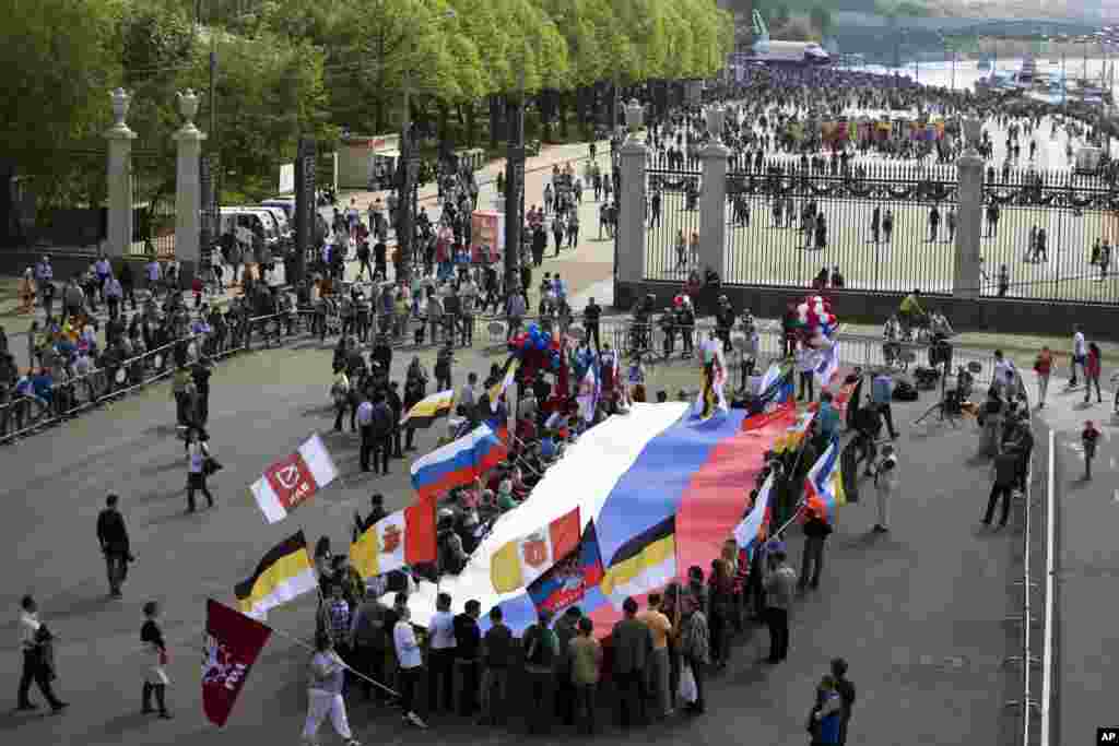 About a hundred people with flags of the self-proclaimed Donetsk People's Republic, as well as Sevastopol and Russian Imperial flags and big Russian flag gather in a rally in Moscow's Gorky Park on May Day, May 1, 2014.