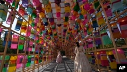 FILE - Visitors wearing face masks to help curb the spread of the coronavirus walk through the lanterns at the Royal Culture Festival at the Gyeongbok Palace, one of South Korea's well-known landmarks, in Seoul, South Korea, Tuesday, Oct. 19, 2021. 