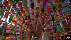 FILE - Visitors wearing face masks to help curb the spread of the coronavirus walk through the lanterns at the Royal Culture Festival at the Gyeongbok Palace, one of South Korea's well-known landmarks, in Seoul, South Korea, Tuesday, Oct. 19, 2021. 