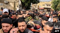 FILE - Mourners march carrying the bodies of Muhammad Ayman Ghazawi and Basel Ayman Ghazawi, two of three Palestinian men killed when undercover Israeli agents raided the Ibn Sina hospital in Jenin, during the the funeral in the occupied West Bank city on January 30, 2024.