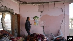 A Palestinian looks at a damaged residential building following an overnight Israeli strike in Deir al-Balah, Gaza Strip, Jan. 8, 2025.