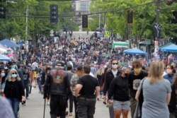 People fill a street June 14, 2020, inside what has been named the Capitol Hill Occupied Protest (CHOP) zone in Seattle, Washington. Protesters calling for police reform and other changes have taken over several blocks near the city's downtown area.