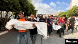가자지구 주민들이 이스라엘의 공습으로 사망한 주민의 시신을 옮기고 있다. 