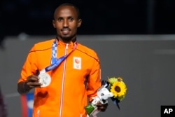 FILE - Silver medalist in the men's marathon Abdi Nageeye, of the Netherlands, poses during the closing ceremony in the Olympic Stadium at the 2020 Summer Olympics, Sunday, Aug. 8, 2021, in Tokyo, Japan. (AP Photo/David Goldman)