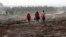Residents walk in the rain at the Solai farm after their dam burst its walls, overrunning nearby homes, in Solai town near Nakuru, Kenya, May 10, 2018. 