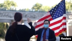 Un empleado del Servicio de Inmigración y Ciudadanía recibe el juramento de un inmigrante en su proceso de naturalización en Los Ángeles, California, el 5 de febrero de 2021.