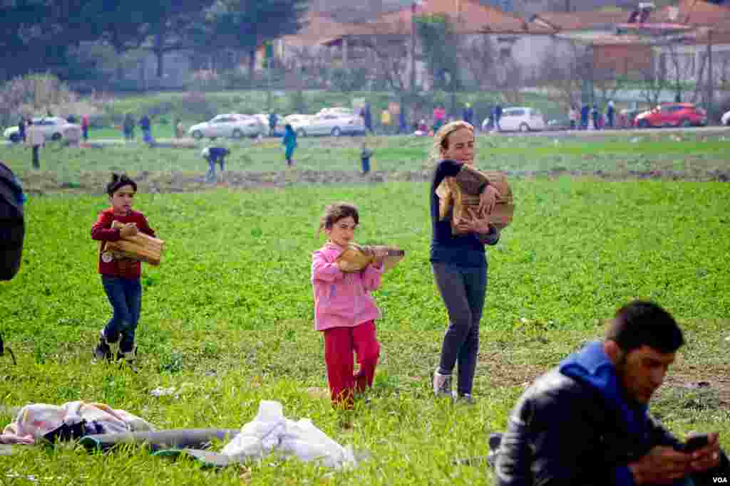 Children carrying some of the wood brought for fires, March 9, 2016. (J. Dettmer/VOA)