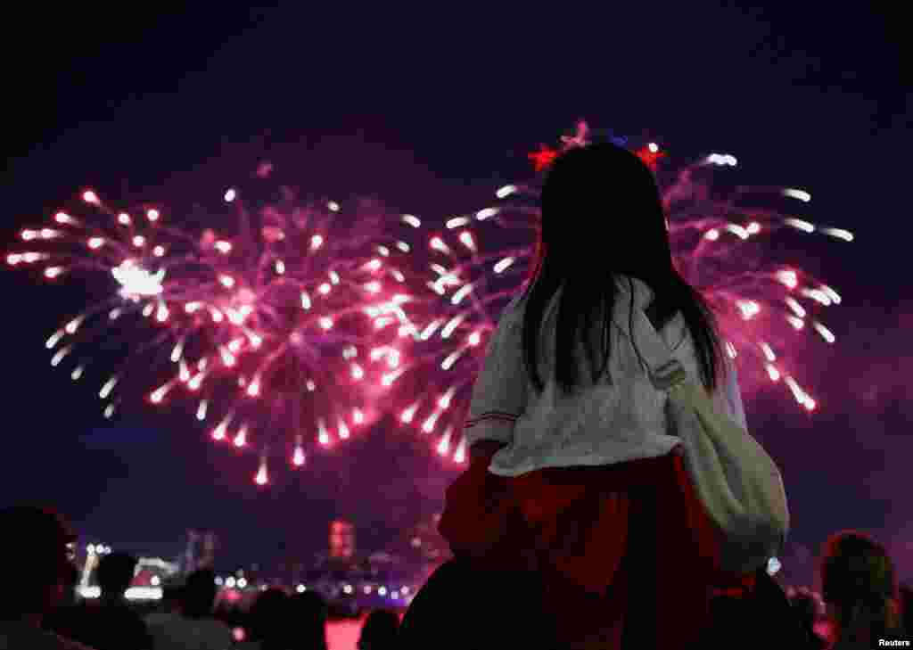2026년 7월 4일 미국 뉴저지주 리버티 주립공원에서 바라본 모습. 한 어린이가 부모의 무등을 타고 미국의 독립기념일 250주년 기념 불꽃놀이를 관람하고 있다.
