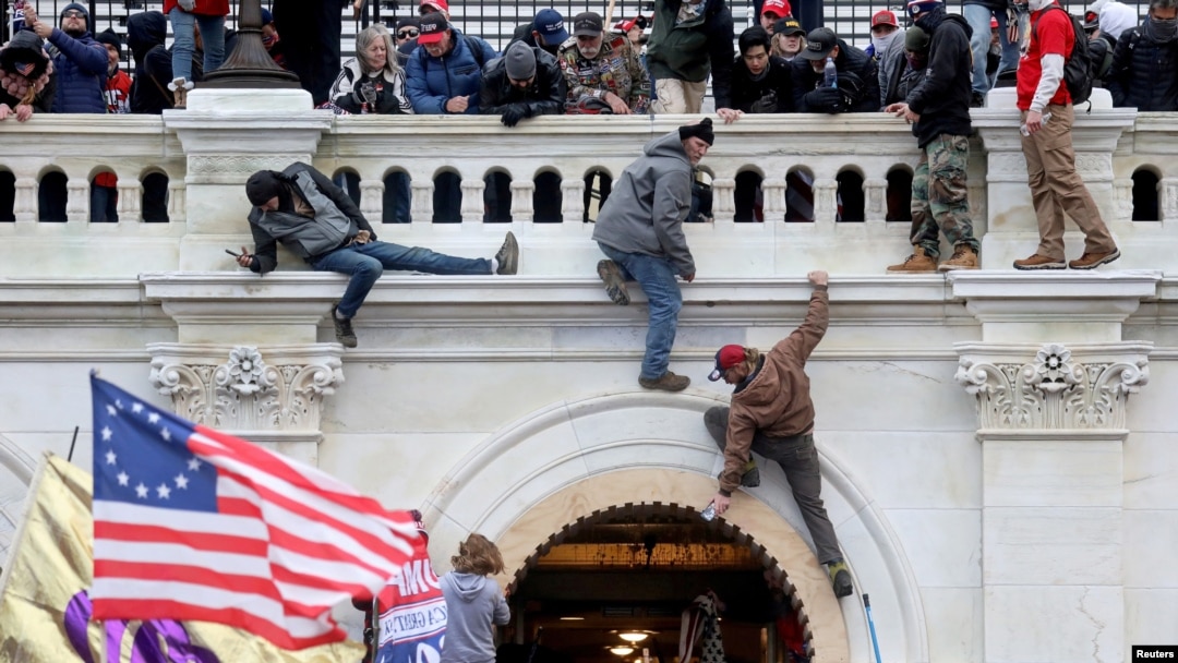 FILE PHOTO: A mob of supporters of U.S. President Donald Trump fight with members of law enforcement at a door they broke open as they storm the U.S. Capitol Building in Washington. January 6, 2021. 