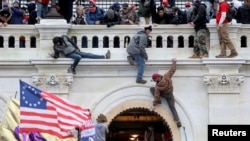 FILE PHOTO: A mob of supporters of U.S. President Donald Trump fight with members of law enforcement at a door they broke open as they storm the U.S. Capitol Building in Washington. January 6, 2021. 