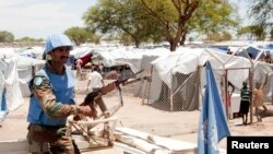 A U.N. peacekeeper keeps guard outside a camp for internally displaced persons in Bor, South Sudan, on April 29, 2014.
