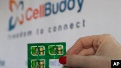 Una empleada sostiene la tarjeta universal SIM de Cell Buddy.