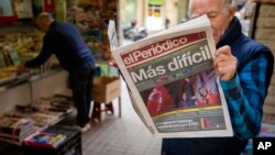 A man reads a newspaper at a newsstand in Barcelona, Spain, Nov. 11, 2019. 
