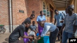 Parishoners wash hands as a preventive measure against the spred of the COVID-19 on the last day of full gatherings at the Saint Don Bosco Catholic Parish in Lilongwe, March 22, 2020.