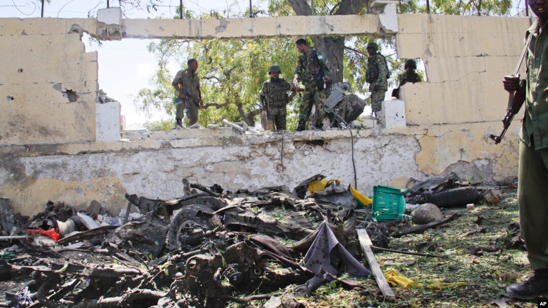 Pasukan Somalia memeriksa lokasi serangan bom mobil oleh militan al-Shabab di Mogadishu, Selasa (14/4).