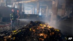 Firefighters work to douse a fire inside a food and beverage factory in Rupganj, outside Dhaka, Bangladesh, July 9, 2021. 