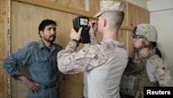 U.S. marines of Fox Co, 2nd Battalion, 7th Marines Regiment get a biometric scan of an Afghan local police trainee before the start of a basic police course training at Combat Outpost Musa Qal-Ah in Helmand province, October 31, 2012.