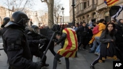 Catalan police officers clash with demonstrators outside a subway after blocking a train rail, during a general strike in Catalonia, Spain, Feb. 21, 2019. 