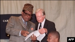 (Archive) Mokonzi ya kala ya RDC (Zaïre) Mobutu Sese Seko (G) azali kosolola na mokonzi ya kala ya ekolo Amerika Jimmy Carter y, 18 sanza ya misato 1996.