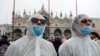 Des touristes portent des masques de protection à Venise en Italie le 23 février 2020.