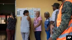 Unas mujeres esperan formadas para votar en las elecciones primarias en Santo Domingo, República Dominicana, el domingo 6 de octubre de 2019. Las elecciones presidenciales serán el 16 de marzo de 2020. (AP Foto/Tatiana Fernandez)