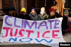 Aktivis iklim Greta Thunberg memblokir pintu masuk Parlemen Swedia saat protes di Stockholm, Swedia 11 Maret 2024. (Christine Olsson/ Kantor Berita TT/via REUTERS)