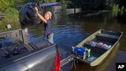 Daniel Stover, 17, loads personal belongings from a friend's home flooded home in Sorrento, La., Aug. 20, 2016. 