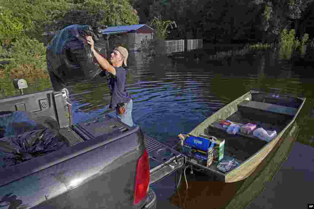 Daniel Stover, 17, loads personal belongings from a friend's home flooded home in Sorrento, La., Aug. 20, 2016. 