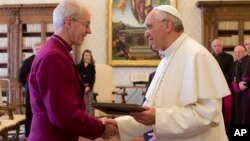 Pope Francis exchanges gifts with the Archbishop of Canterbury, Justin Welby, during a private audience at the Vatican on June 14, 2013.