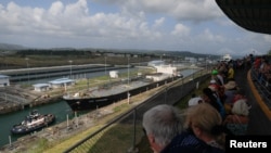 FILE - A boat and a ship cross through the Panama Canal in Agua Clara, on the outskirts of Colon City, Panama, January 20, 2024.