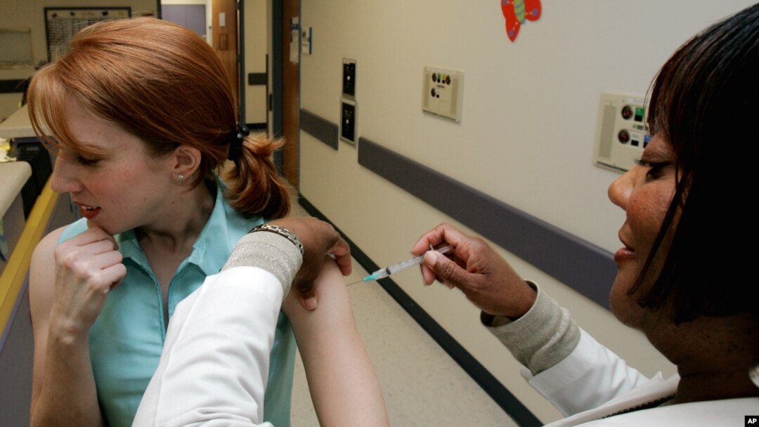 FILE - A woman is given a flu shot on the Emory University campus in Atlanta. 