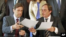 Pedro Passos Coelho (L), leader of Social Democrat Party (PSD) and Paulo Portas, leader of Popular Party, exchange their coalition agreement documents for the government in Lisbon, Portugal, June 16, 2011