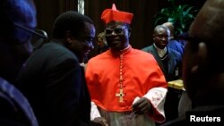 FILE - Cardinal Laurent Monsengwo of the Democratic Republic of Congo receives guests in the Paul VI hall at the Vatican, Nov. 20, 2010.