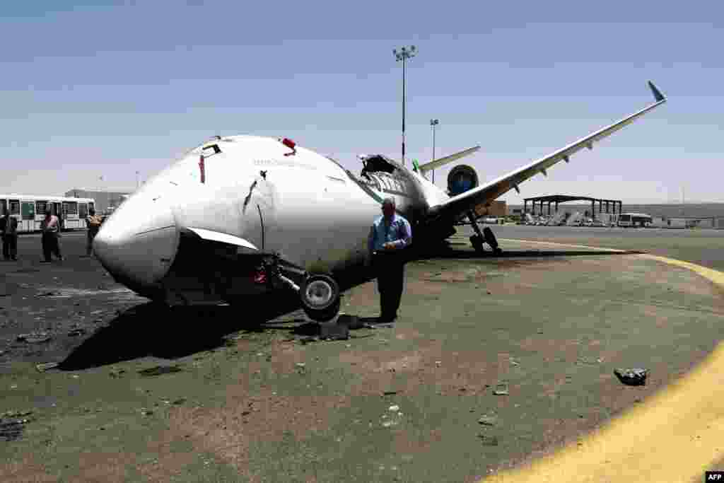 A Yemeni airport official looks at a destroyed Felix Airways plane, after it was hit in an air strike, at the international airport of Yemen&#39;s capital, Sana&#39;a.